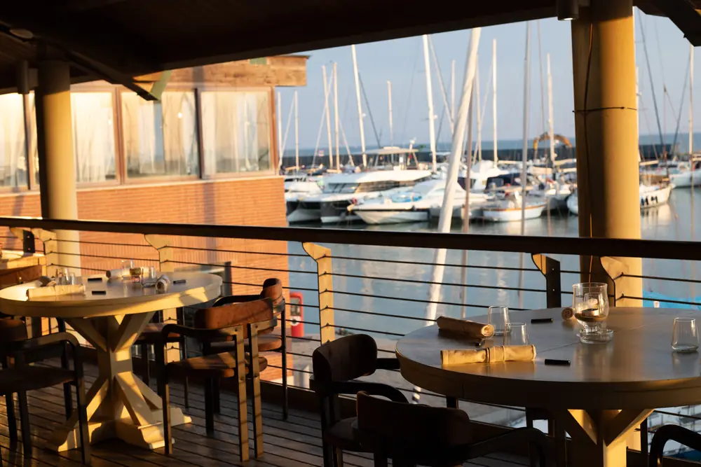 La sala di Brasa affacciata sulle barche del porto turistico