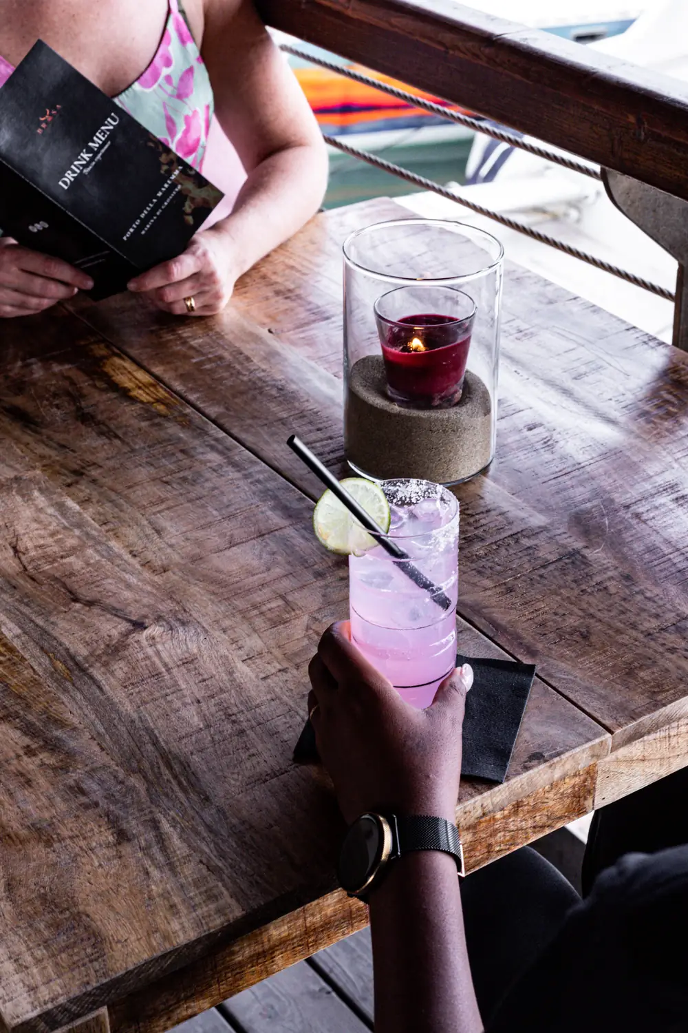 Due cocktail su un tavolo di legno affacciato sul porto