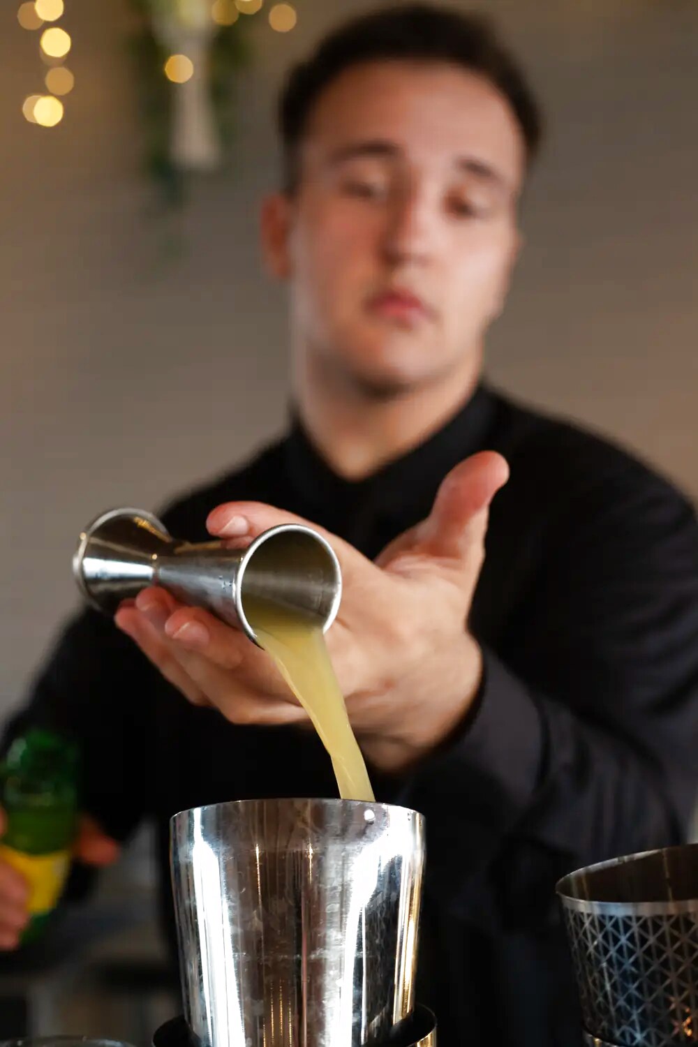 Un barman prepara un cocktail al bancone